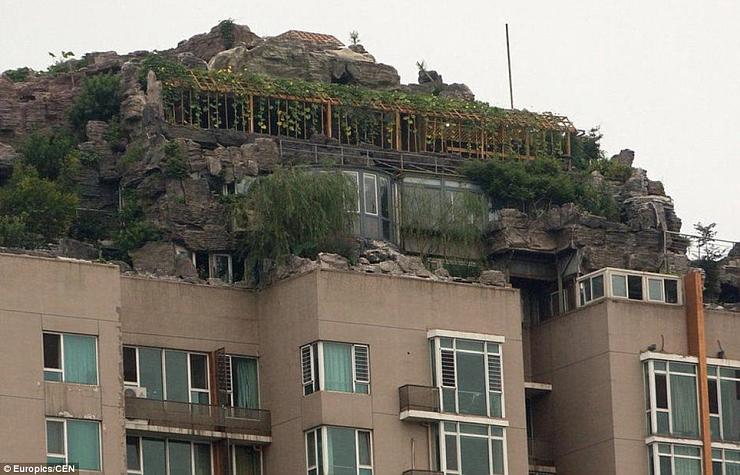 بالصور : صيني يبني هضبة صخرية وفوقها فيلا على سطح عمارة